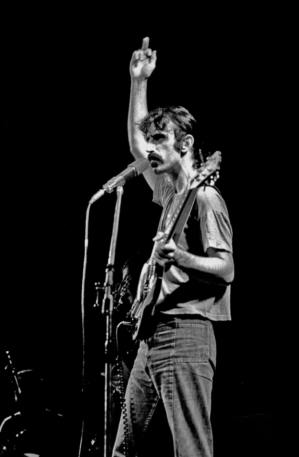 Zappa playing guitar giving the middle finger.